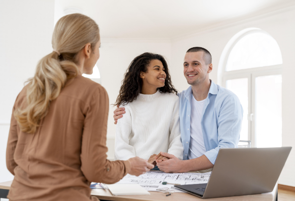 happy-embraced-couple-conversing-with-female-realtor